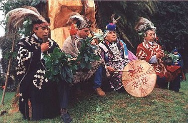 Mapuche people dressed in traditional wear and performing.