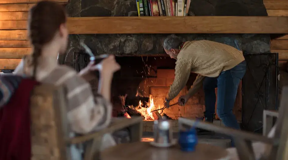 two persons in front of a fireplace