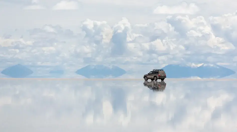 4WD driving on Salar de Uyuni with cloud and mirror effect