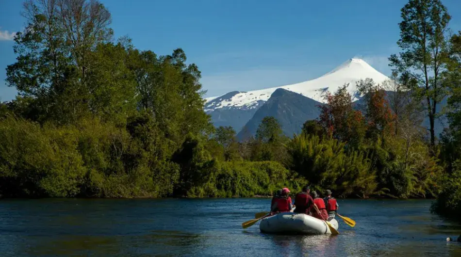 Rafting on calm water with snowy volcano in background