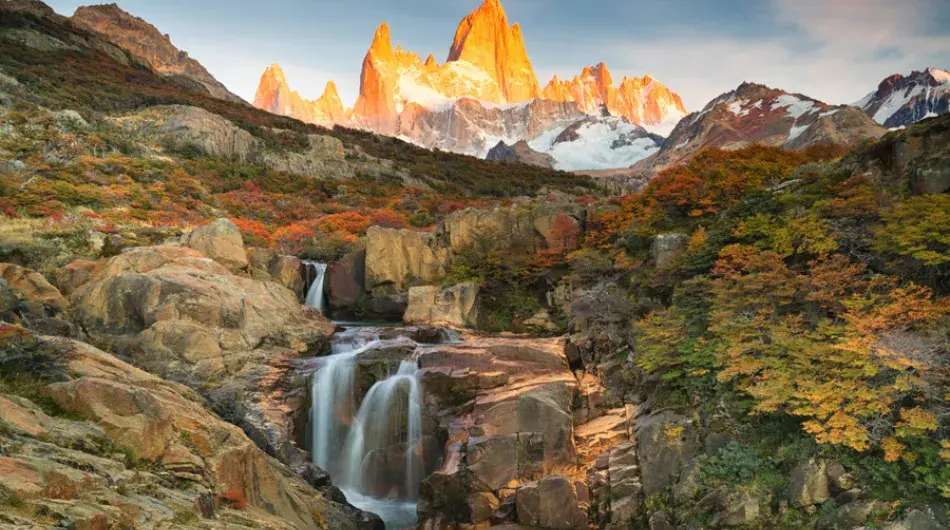 Fitz roy mountain peak with waterfall and orange sunset