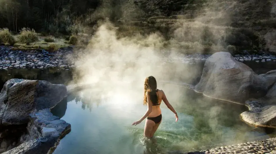 Girl entering hot spring smoky waters near colca canyon