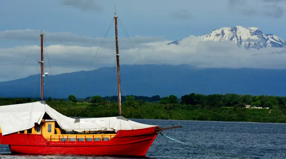 Red ship on llanquihue lake with osorno volcano
