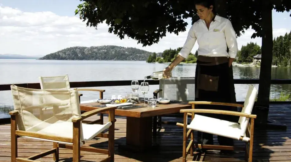 Waiter serving wine on a terrace near Nahuel Huapi lake in Bariloche
