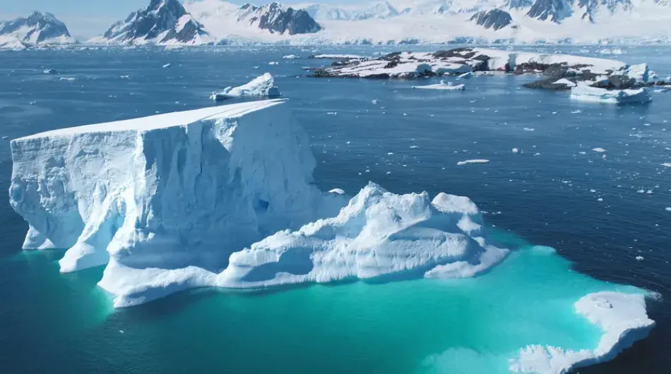 Aerial view of an Iceberg in clear turquoise waters in Antarctica