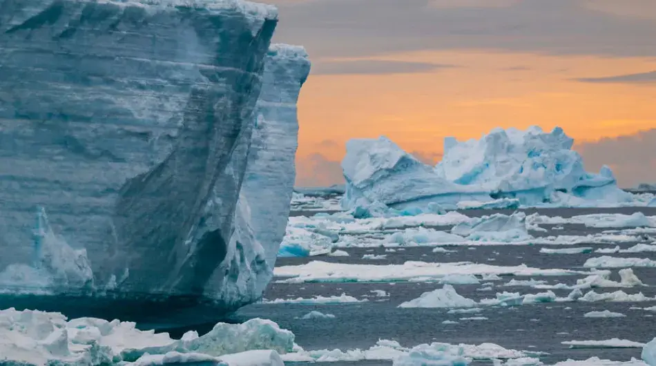 Iceberg at orange sunrise