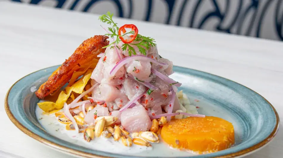 Peruvian ceviche in a blue plate with a sweet potato slice
