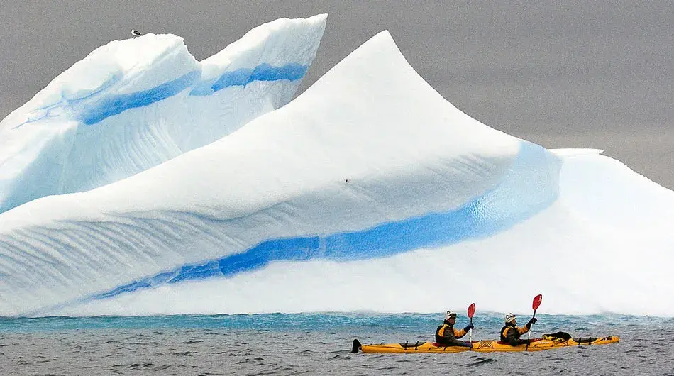 kayaking in front of iceberg Antarctica