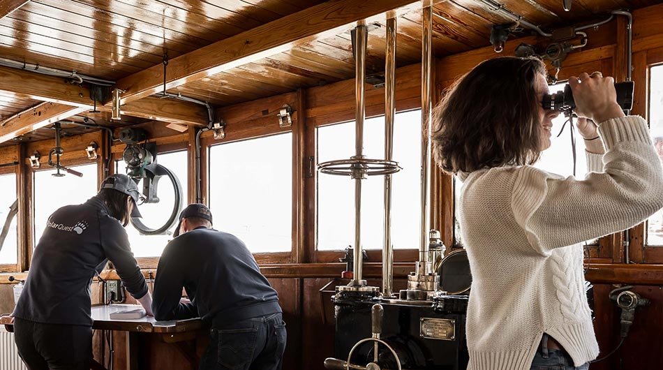M/S Stockholm - guest looking for Arctic wildlife with binoculars 