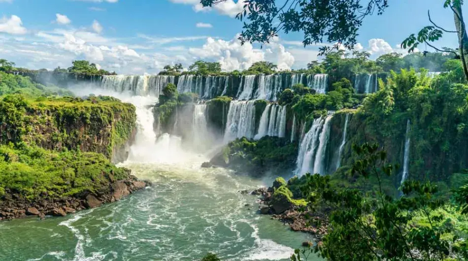 Iguazu waterfall with lush forest and blue sky
