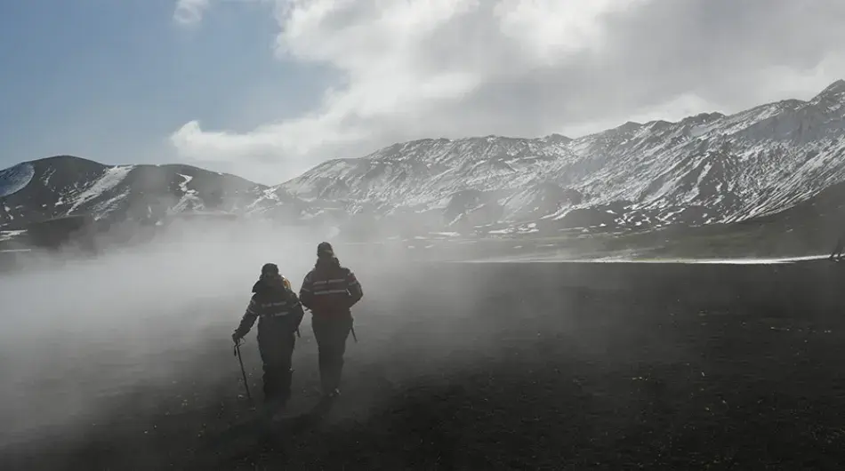 two expedition cruise guests on foggy beach walk in Antarctica
