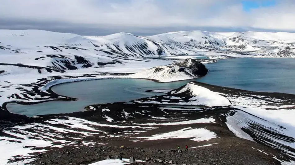 Aerial view of Deception Island with patches of snow in Antarctica