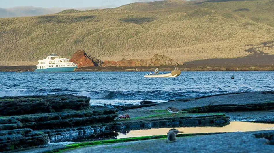 Landscape view of the Galapagos Islands with the Natural Paradise ship and panga in the background