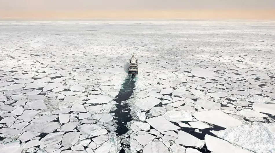 Expedition ship cruising through pack ice in Antarctica