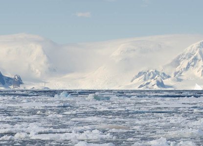 Frozen waters of Antarctica with snowy mountains in background) 