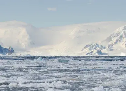 Bay filled with brash ice with snowy mountains of Antarctica in background) 
