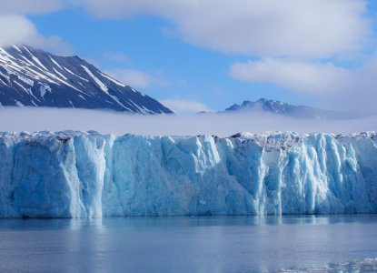 Large Glacier in Svalbard with mountains in the background and calm waters in foreground) 